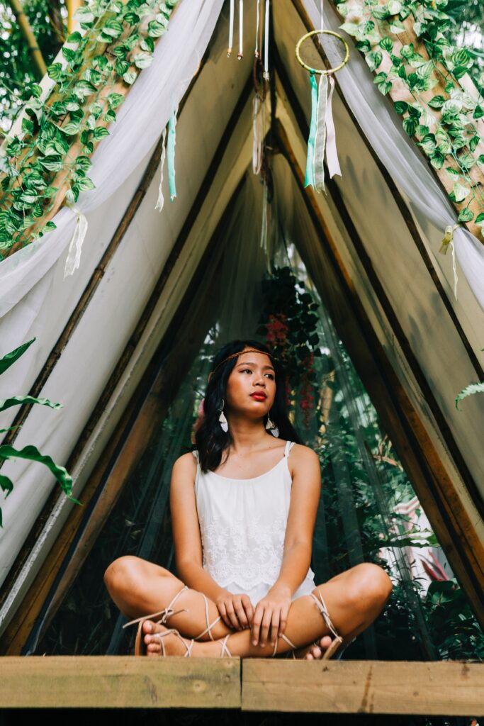 Woman sitting inside a Boho tent.